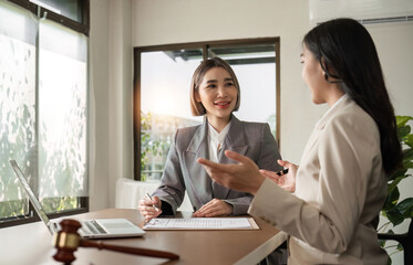Obraz premium A young lawyer and businesswoman are discussing legal advice on signing a business contract. Insurance or financial contract signing
