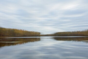 Obraz premium ICM Intentional camera movement with long exposure lake view in autumn abtract background.