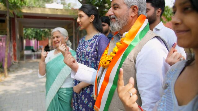 An Indian politician with candidates showing the ink-marked index finger to encourage the Indian citizens - democracy  right to vote  registered voters. A political party leader asking for support ...