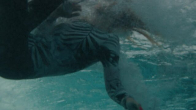 Underwater view of the woman surfer falling into the water