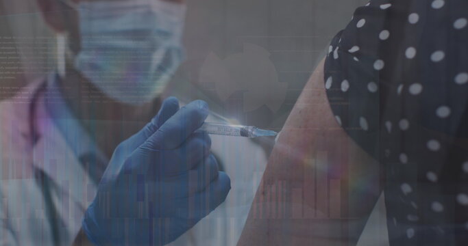 Image of data processing over caucasian male doctor with face mask vaccinating