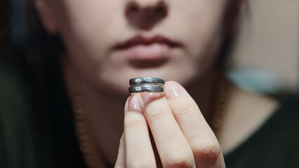Woman goldsmith looking at crafted silver ring. Jewelry handicraft. Close up