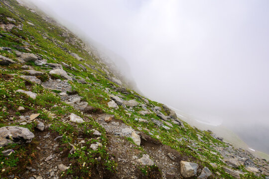 mountainous romanian landscape on a foggy day. scenery with steep rocky hillside. summer vacations in fagaras