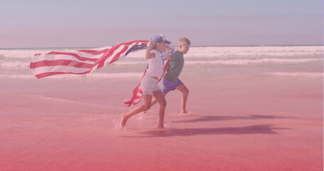 Naklejka premium Image of smiling caucasian siblings with american flags running at beach
