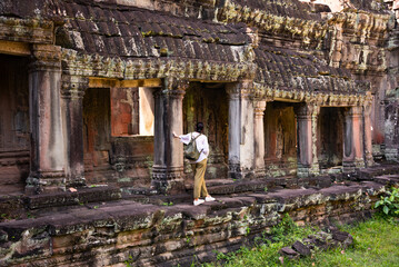 Female tourist looking at ancient Angkor temple in Cambodia