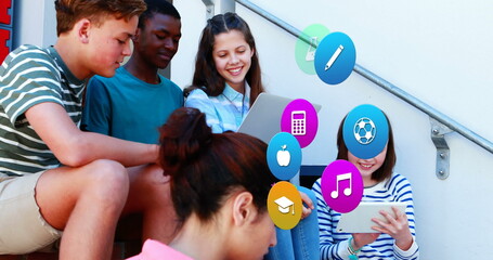 Image of colorful icons over diverse schoolchildren using tablets