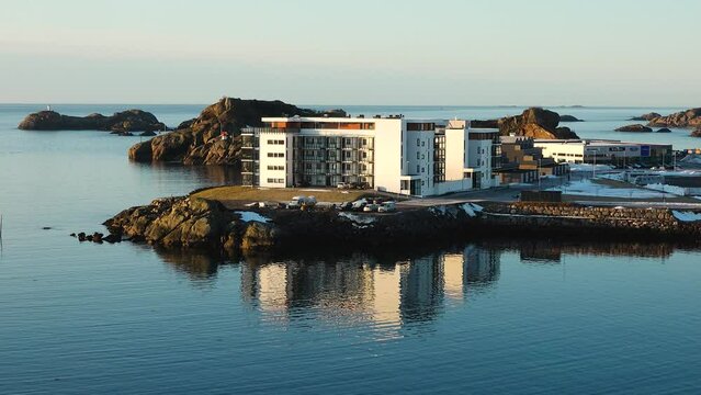 Svolvaer, Lofoten, Norway - March 2024: Houses on the water with reflection. Modern apartments on the fjord shore. Traditional red fishermen's cabins. Tourist town on the Lofoten Islands. Rorbu.