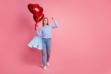 Full size photo of excited girl holding balloons shopping bags raising fist up celebrate birthday...