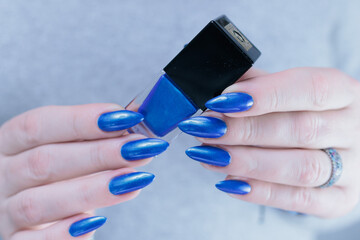 Woman's beautiful hand with long nails and bright blue manicure