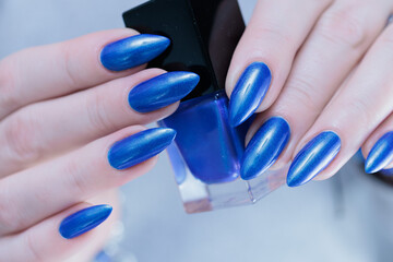 Woman's beautiful hand with long nails and bright blue manicure