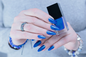 Woman's beautiful hand with long nails and bright blue manicure