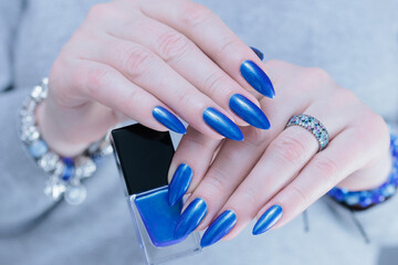 Woman's beautiful hand with long nails and bright blue manicure