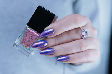 Female hand with long nails and a blue lilac color nail polish