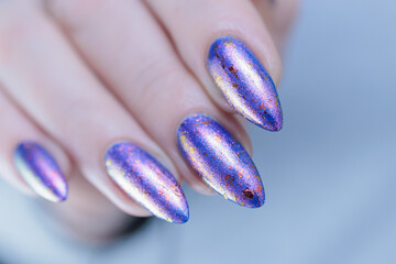 Female hand with long nails and a blue lilac color nail polish
