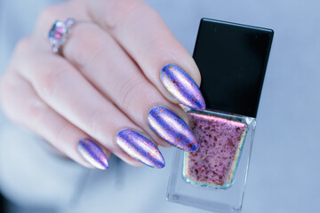 Female hand with long nails and a blue lilac color nail polish
