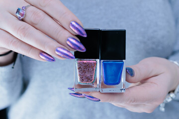Female hand with long nails and a blue lilac color nail polish