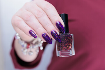 Female hands with long nails and dark purple manicure 