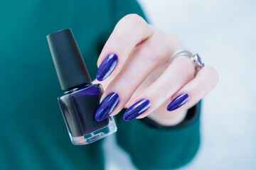 beautiful female hand with long nails and purple blue manicure 