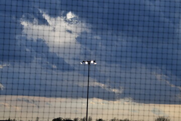 Mesh Fence and Stadium Lights at a Baseball Stadium