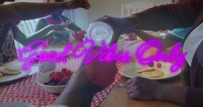 Image of good vibe only text over african american family eating meal together in the kitchen