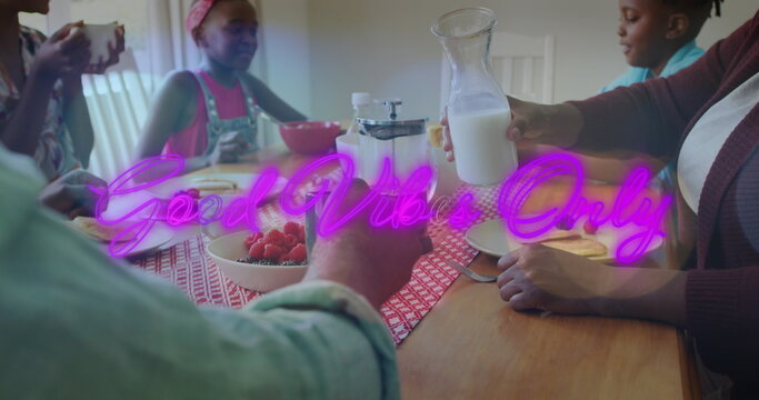 Image of good vibe only text over african american family eating meal together in the kitchen