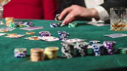 Extreme close-up of poker cards and chips in a casino. Casino clients playing at the table, strategy of winning combinations, gambling. - Powered by Adobe