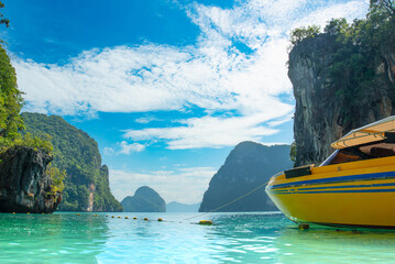 A serene tropical beach scene, featuring a vibrant yellow boat anchored near lush green cliffs...