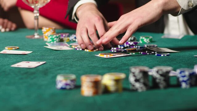 Extreme close-up of poker cards and chips in a casino. Casino clients playing at the table, strategy of winning combinations, gambling.