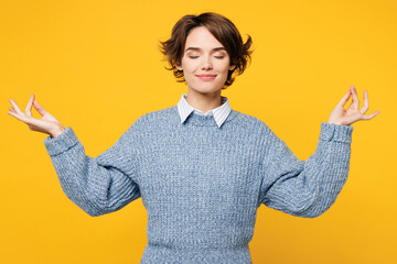 Young woman wears grey knitted sweater shirt casual clothes hold spreading hands in yoga om aum...