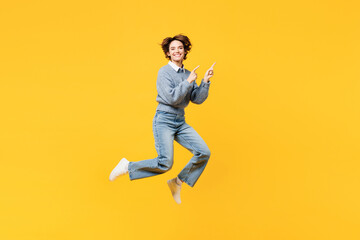 Fototapeta na wymiar Full body young woman she wearing grey knitted sweater shirt casual clothes jump high point index finger aside on area workspace mock up isolated on plain yellow background studio. Lifestyle concept.
