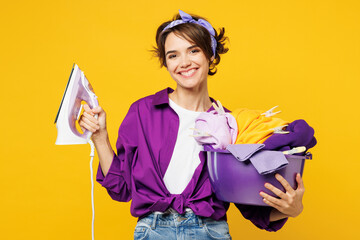Young smiling cheerful happy fun woman she wears purple shirt do housework tidy up hold in hand...