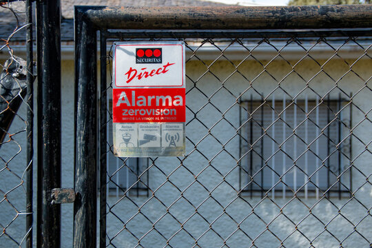 Alarm warning sign attached to a fence or wall