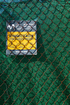 Alarm warning sign attached to a fence or wall