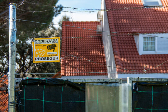 Alarm warning sign attached to a fence or wall