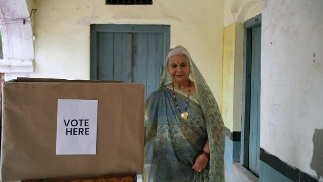 An Indian elderly lady giving her vote in the EVM - registered voters  general elections  election process  democracy. An old lady showing thumbs up after completing the voting process - public ser...