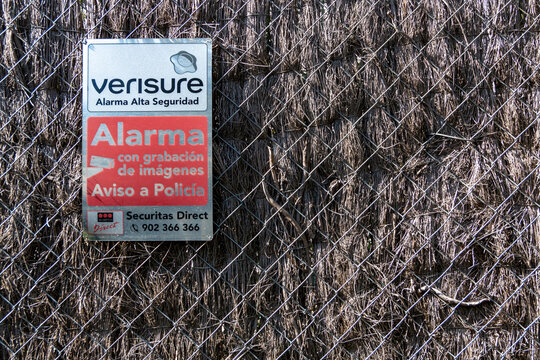 Alarm warning sign attached to a fence or wall