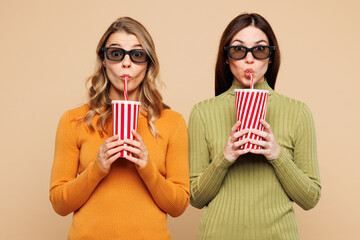 Young friends two women they wears orange green shirt casual clothes together hold in hand cup of...