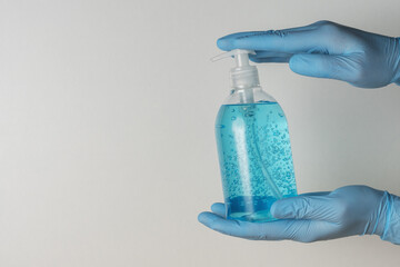 Hands in medical gloves with hand sanitizer in a bottle on white background. Coronavirus prevention...