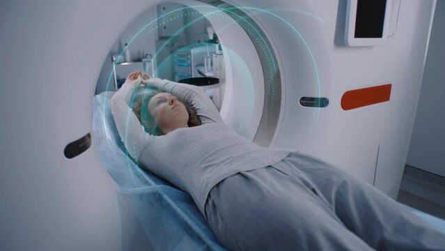 Female patient undergoes MRI or CT scan, lies on bed moving inside the machine. Visual effects of scanning brain and body of woman. High-tech extended reality equipment in advanced medical laboratory.