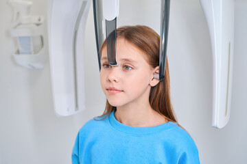 Young female patient is restrained for a dental x-ray