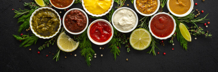 Different types of sauces in bowls with seasonings banner, rosemary and dill, thyme and and peppercorns, top view, copy space