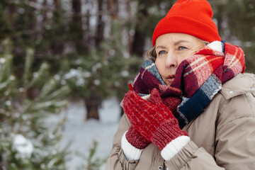 Woman red hat and checkered scarf feeling cold and shivering