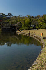 Fototapeta premium 日本 滋賀県彦根市の大名庭園、玄宮園の臨池閣と魚躍沼と彦根城の天守閣