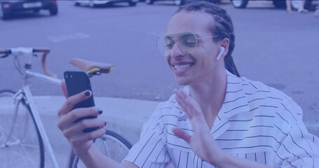 Image of light spots over happy biracial man using smartphone