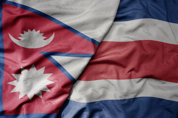 big waving national colorful flag of costa rica and national flag of nepal .