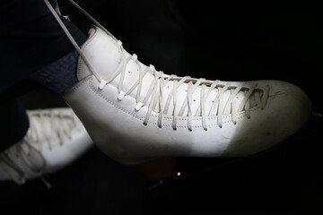 Lace up a white figured ice skate.