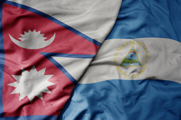 big waving national colorful flag of nicaragua and national flag of nepal .