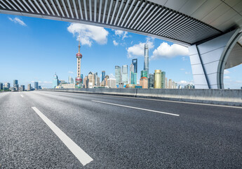 Asphalt highway road and pedestrian bridge with modern city buildings in Shanghai