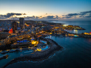 St. Julian's city, high buildings. Drone sunset night view. Maltese island