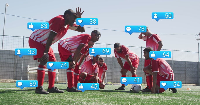 Image of social media icons over tired diverse male soccer players taking break on sports field - Powered by Adobe